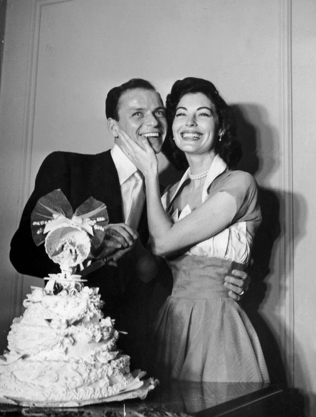 7th November 1951: American pop singer Frank Sinatra poses with his wife, American actor Ava Gardner, standing behind their wedding cake on their wedding day. Gardner holds her hand on Sinatra's cheek. (Photo by Hulton Archive/Getty Images)