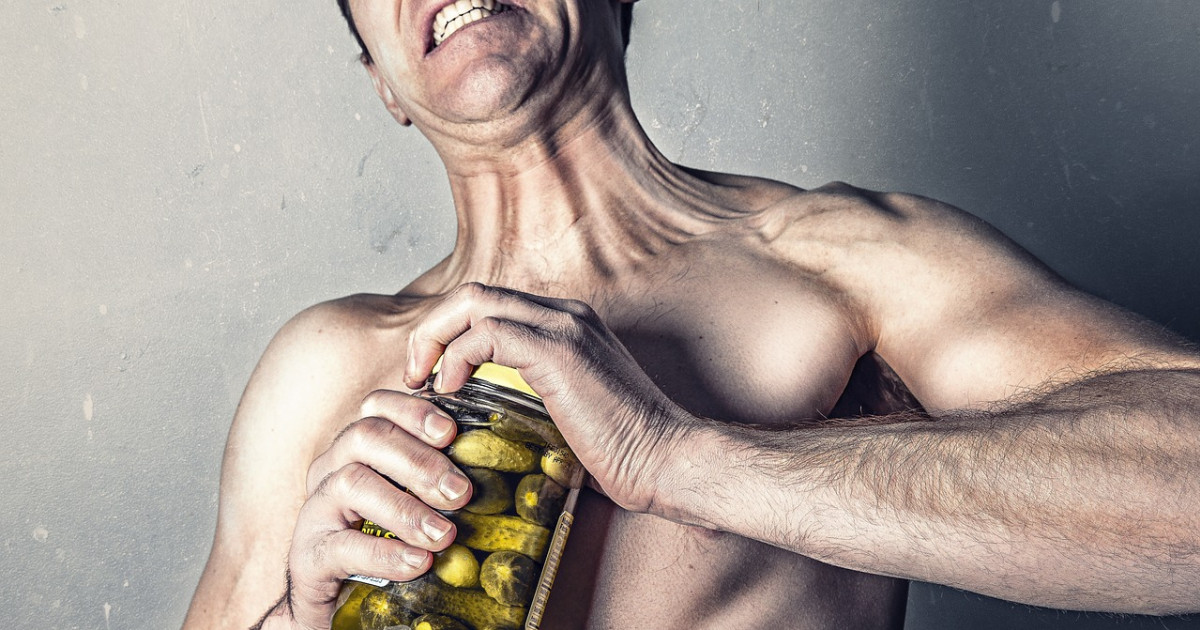 Befőttesüveg tetejét lecsavaró férfi