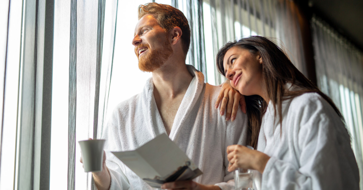 Fiatal pár gyerekmentes hotelben, szállodai köntösben.